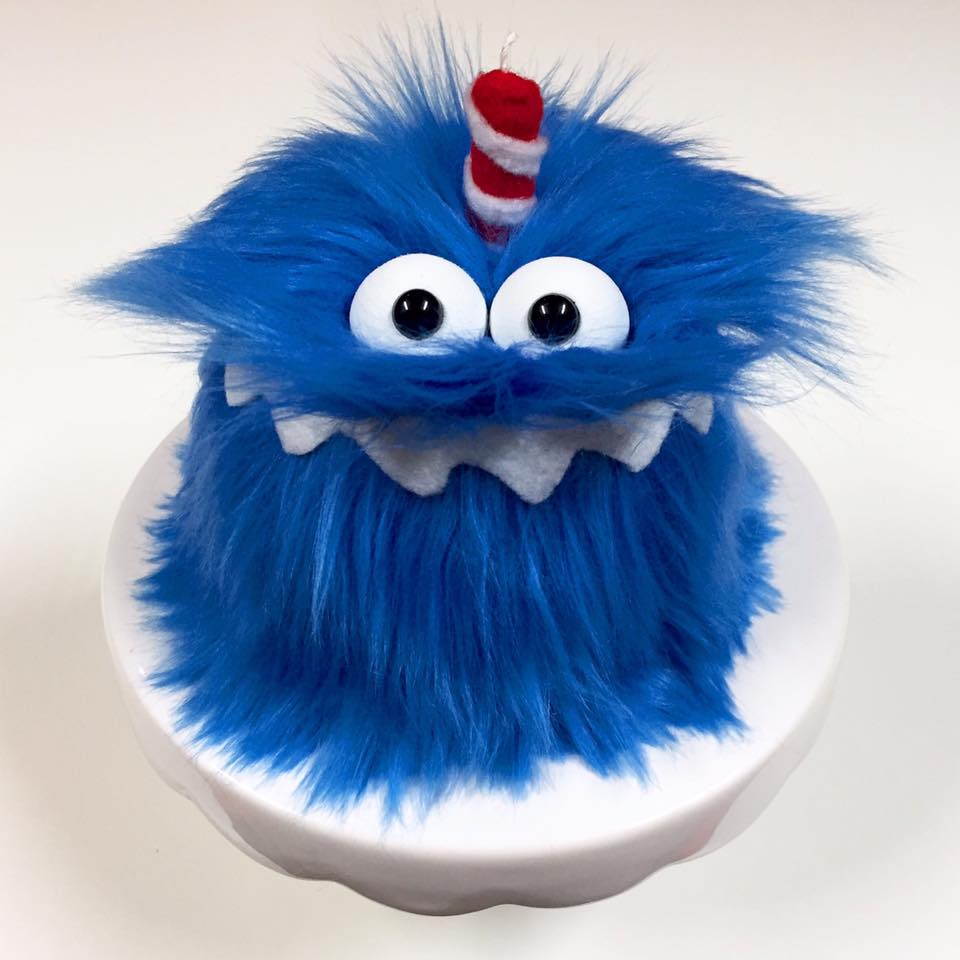 picture of a blue monster birthday cake with a red candle 